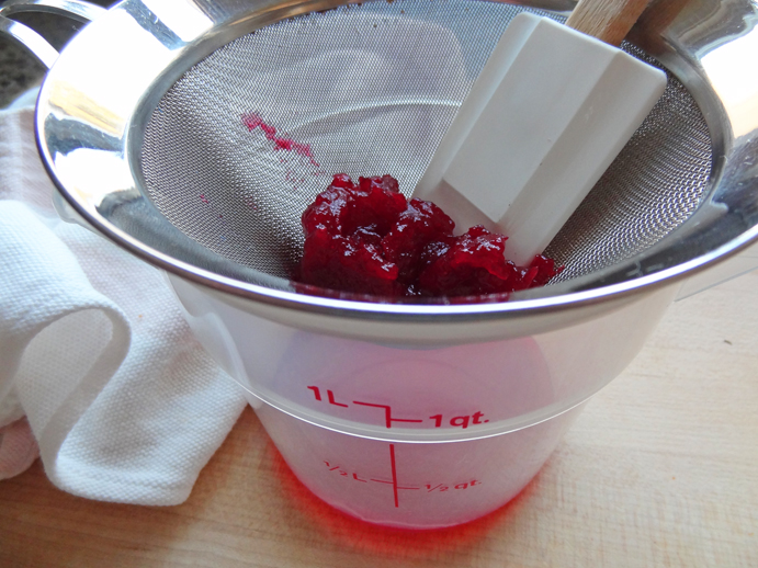 Strain the cranberry compote through a fine-mesh strainer to extract the syrup